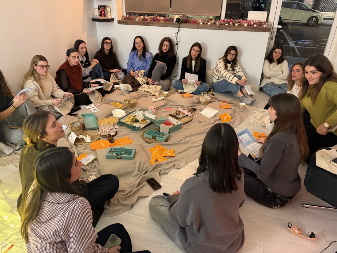 Asistentes sentadas en el suelo charlando